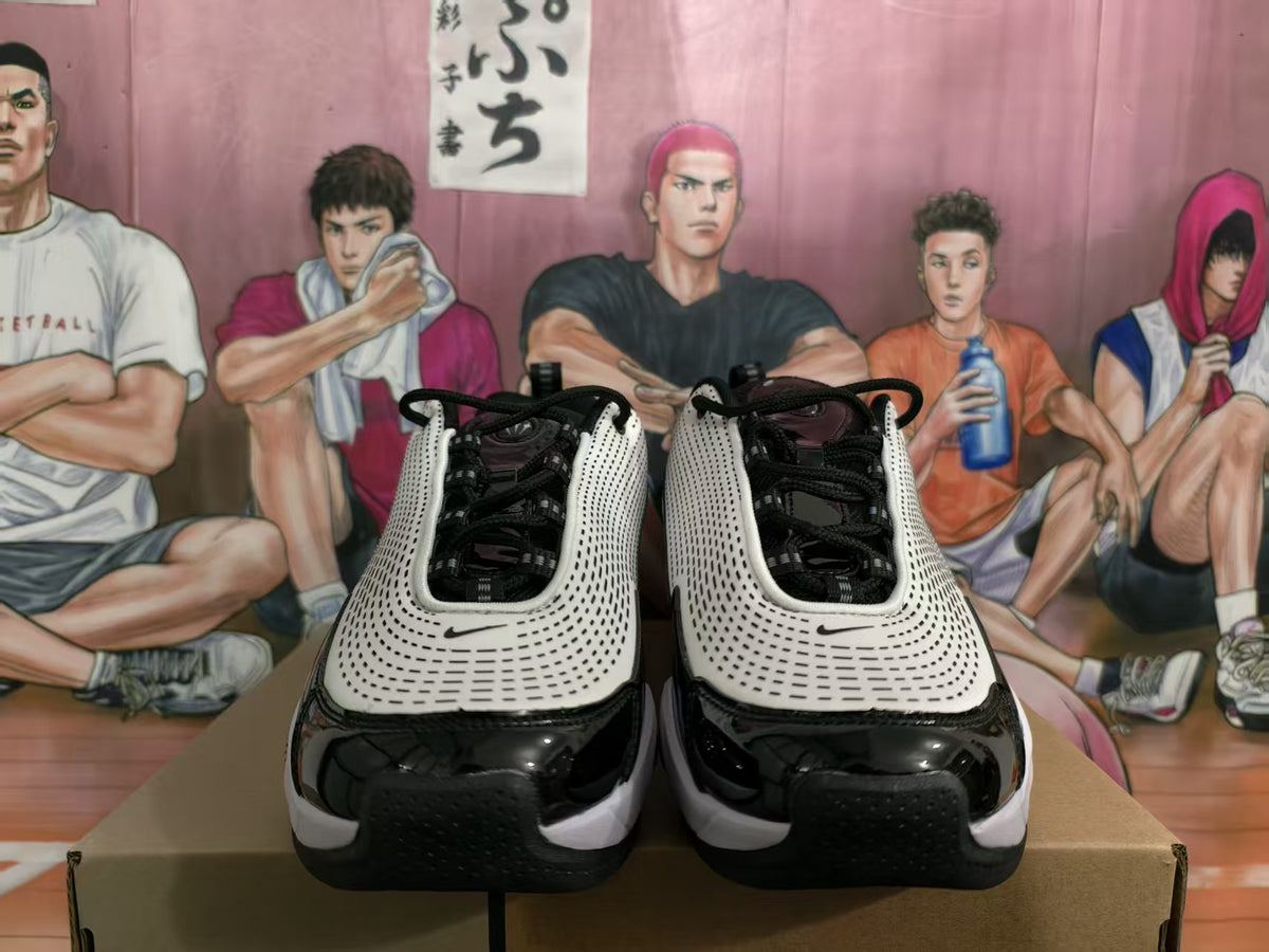 Front view of black and white Nike sneakers with perforated white uppers and black toe panels.