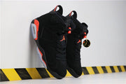 Pair of black and infrared high-top sneakers displayed at an angle, showing the tongues, laces and pull tabs.