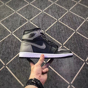 Side profile of a black and grey high-top sneaker with a winged basketball-style ankle emblem and white midsole.