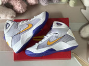 Top-down side view of the pair highlighting the white uppers, gold Swooshes, and patterned purple outsoles.