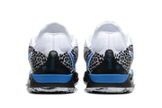Rear view of white Nike basketball shoes with black patterned heel panels and blue accents