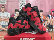 Angled view of the black and red Nike sneakers showing the side branding, tongue details, and outsole construction.
