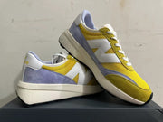 Angled view of yellow, white, and lavender New Balance U370 sneakers