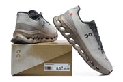 Gray and taupe On Cloudmonster 3 sneakers displayed with a box showing sample size US 8.5