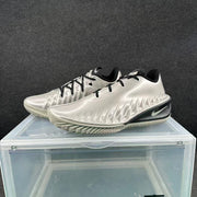 Pair of metallic silver Nike sneakers with black laces and black midsole accents shown from a front three-quarter angle.