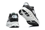 Heel and outsole views of black and white On Cloudtilt Remix sneakers.
