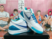 Pair of white and blue basketball sneakers displayed on a black shoebox, showing the Swoosh, blue laces, translucent blue heel detail, and basketball-themed background.