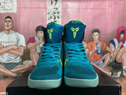Front view of blue high-top basketball shoes with volt-colored tongue logos and pale aqua outsoles.