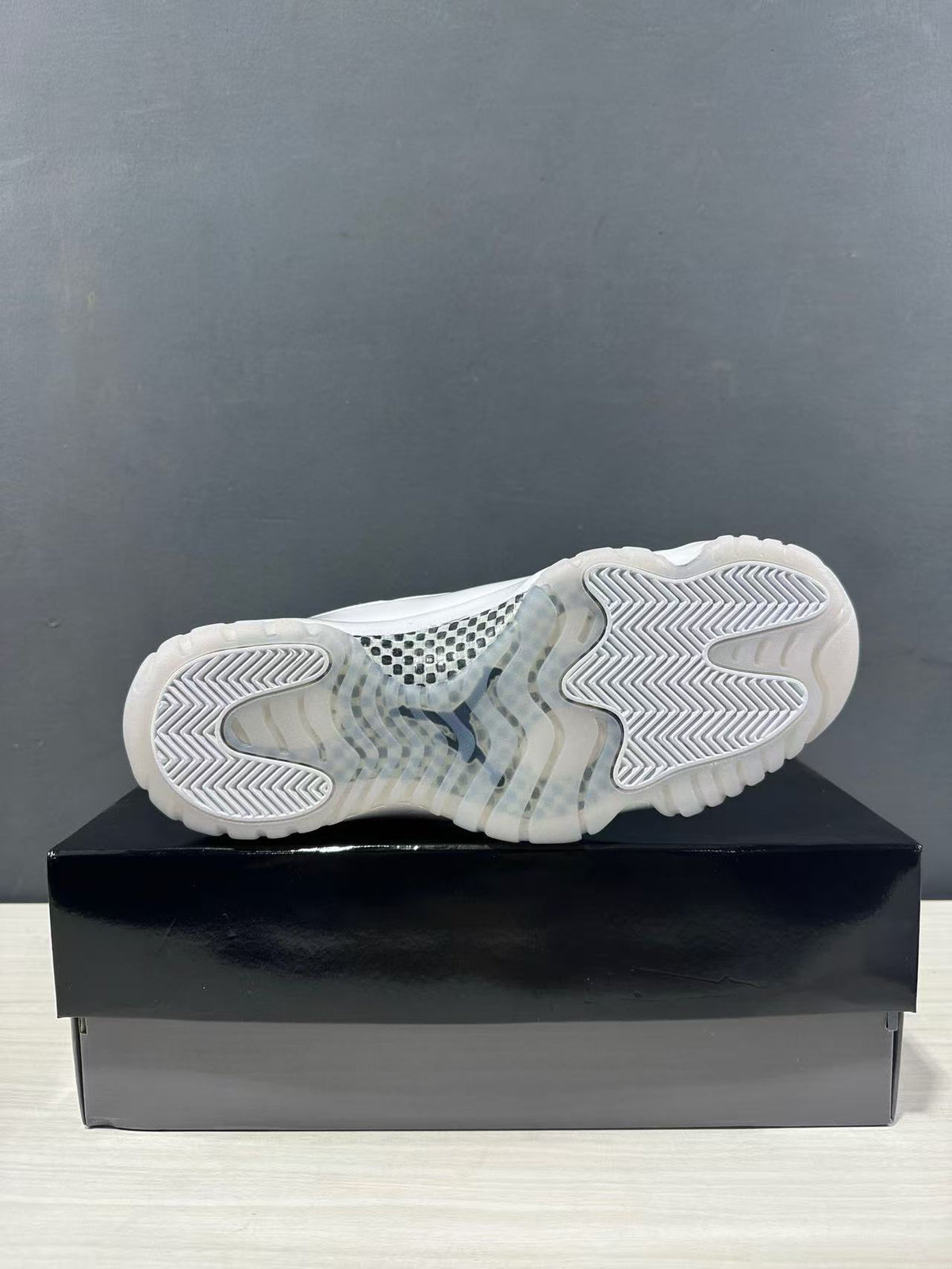 Outsole view of white high-top sneakers showing translucent sections and patterned traction.