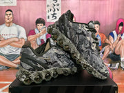 Angled view of the pair highlighting the camouflage-style pattern, side branding, and circular outsole elements.