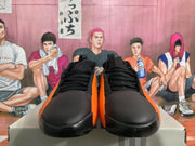 Front view of black and orange sneakers showing black laces, black toe boxes, and orange side accents.