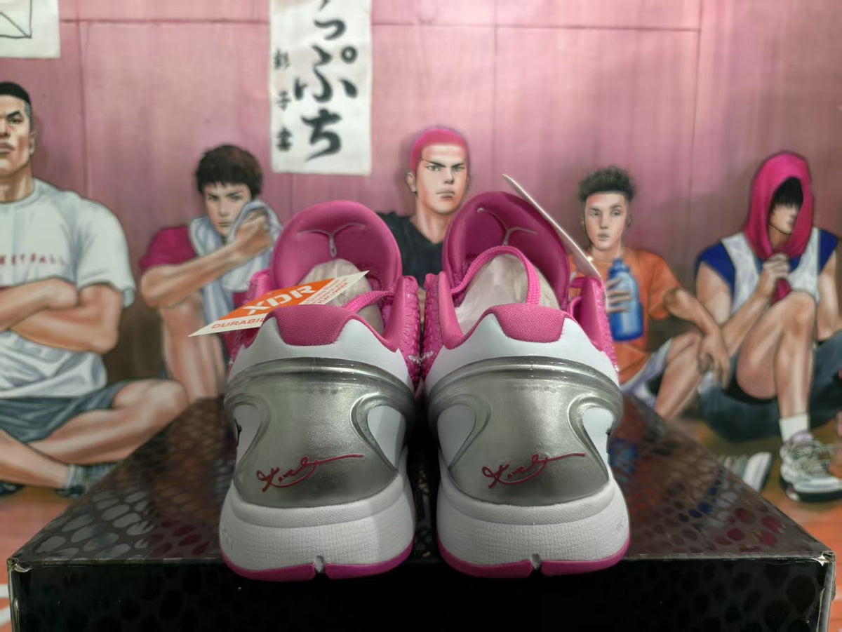 Rear view of pink and white basketball sneakers showing silver heel panels, pink collar details, and Kobe-related heel markings.
