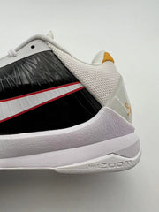 Rear-side detail showing the white heel collar, gold-toned accent, and pale midsole