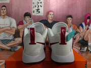 Rear view of white and burgundy Nike basketball sneakers resting on an orange shoebox.