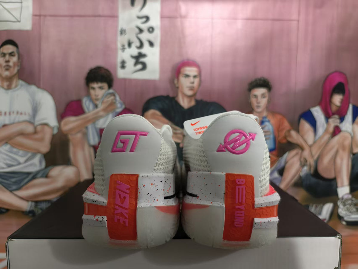 Rear view of white Nike GT sneakers with pink and orange heel details, displayed on a shoebox.