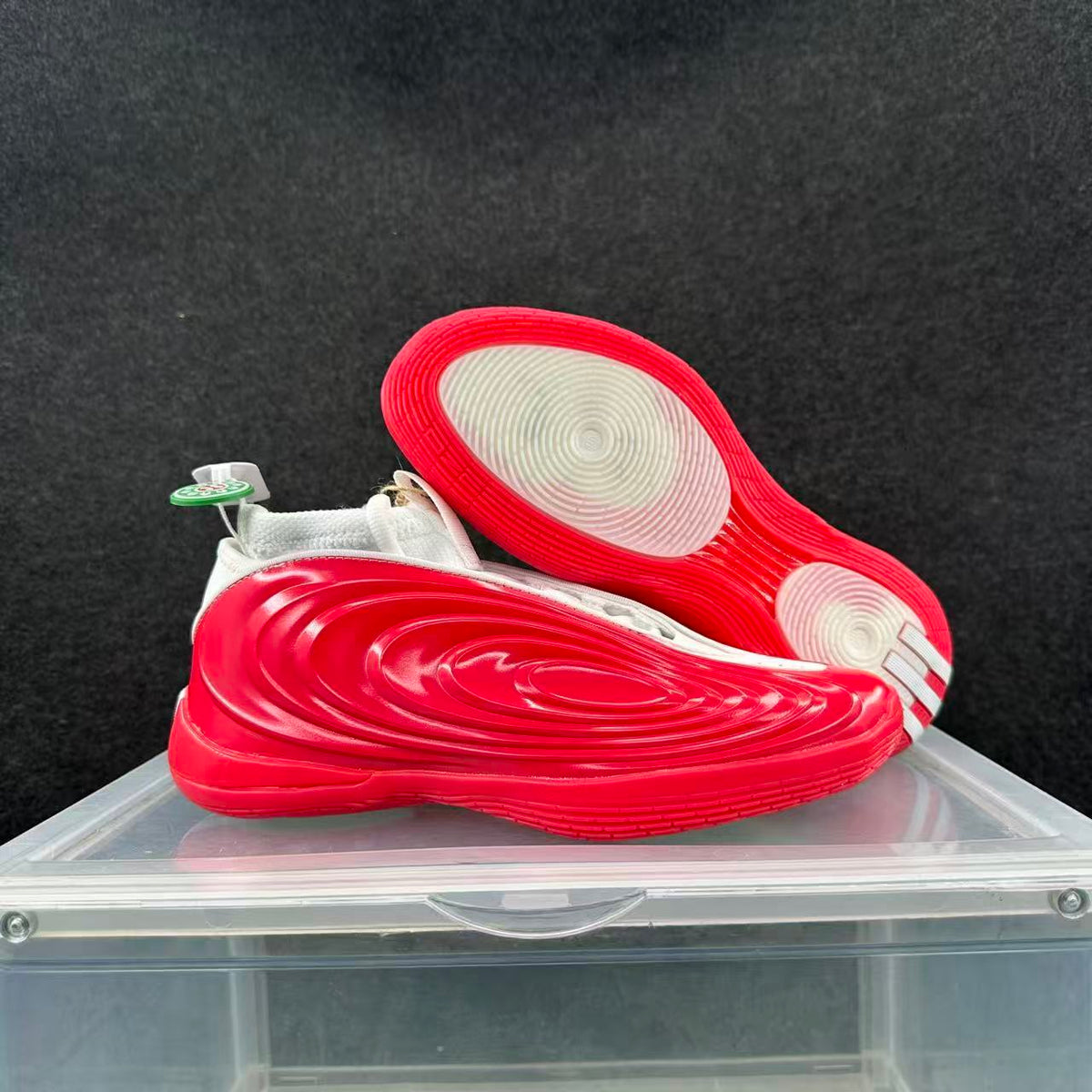 Red and white sneakers shown from the side and outsole, highlighting the layered sole design and circular traction pattern.