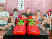 Front view of a pair of red-orange basketball shoes with bright green laces and textured uppers.