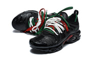 Pair of black Nike Air Max Plus sneakers with white, green, and red laces.