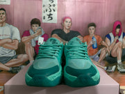 Front view showing the blue-green laces, padded tongues, and darker toe accents.