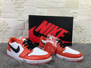 Pair of white, orange and black low-top sneakers displayed with a black Nike shoebox and an extra orange lace set.