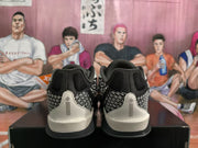 Rear view of the black and light-gray Nike sneakers, showing the patterned heel panels and light-gray heel overlays.