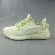 Side profile of the pale butter-yellow sneaker with a textured upper and ribbed sole.
