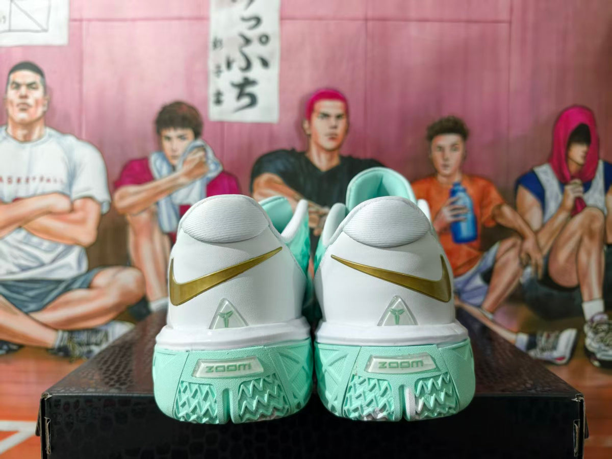 Rear view of white and mint green basketball sneakers with gold Nike Swooshes and Zoom branding on the outsole.