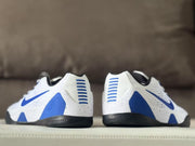 Rear view of the white and blue sneakers showing blue heel accents and black heel sections.