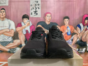 Front view of black On Running sneakers with lace-up closures and rounded toes.