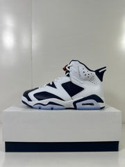 Single side profile showing the layered white and navy upper and visible heel cushioning.