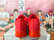 Rear view of the red sneakers showing small heel Swoosh details and glossy heel sections.