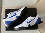 Nike Kobe 9 sneakers arranged on a black box, showing their white, blue and black color scheme.