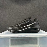 Side profile of a black sneaker with silver branding, layered overlays, and a textured rubber sole.