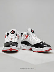Front three-quarter view showing the glossy black toe panels, white uppers, red accents, and Jordan logos.