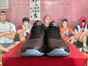 Front view of black, purple, and gold Nike basketball sneakers with black laces and perforated toe panels.