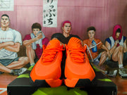 Front view of orange Nike basketball shoes with black outsole accents.