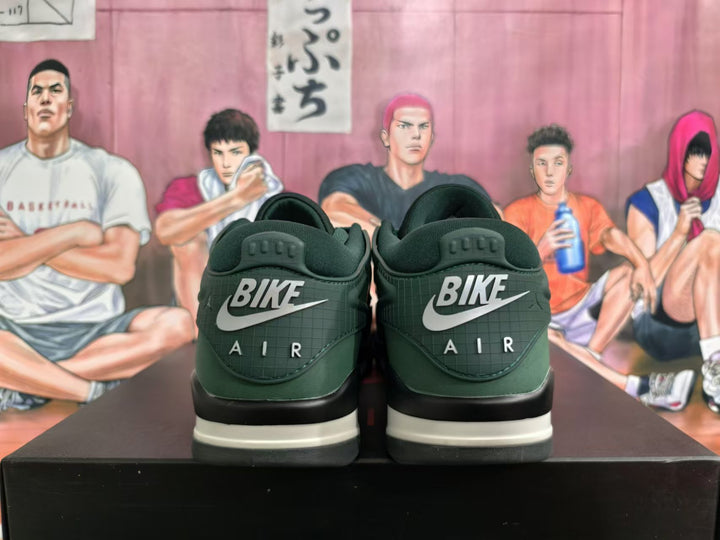 Rear view of green low-top sneakers with heel lettering, a light midsole and black outsole