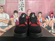 Front view of black and red Jordan 4-style sneakers showing red mesh panels and lace hardware.