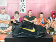 Side view of black Nike basketball shoes with gold Swoosh detailing