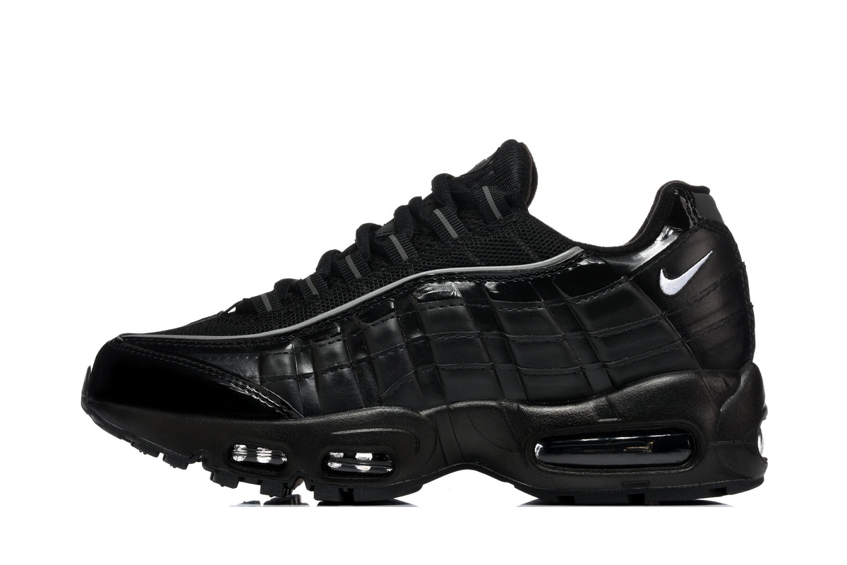 Black Nike Air Max 95-style sneaker with layered side panels, mesh upper, white Swoosh, and visible air units