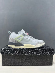 Side profile of a Jordan Spizike Low sneaker showing the grey and white upper, elephant-print overlays, pale green support panel, and visible midsole window.