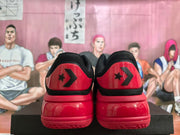 Rear view showing the red heel panels with black star-chevron branding and textured red outsoles.