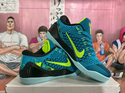 Pair of blue and volt Nike basketball sneakers shown from an angled side view on a shoebox.