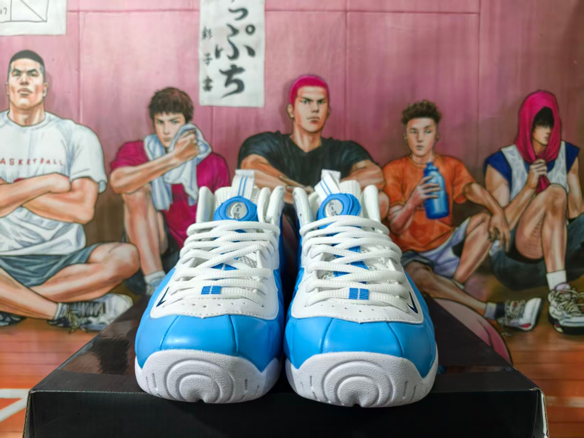 Front view of blue and white Nike sneakers with white laces and textured white outsoles on a black shoebox.
