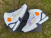 Pair of map-print high-tops arranged over a black shoebox outdoors