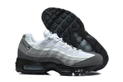 Side view of grey and white Nike Air Max 95 TT sneakers with black soles