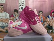 Angled view of the mismatched pink Nike sneakers showing contrasting side colors, silver Swoosh branding, textured uppers, and rubber outsoles.