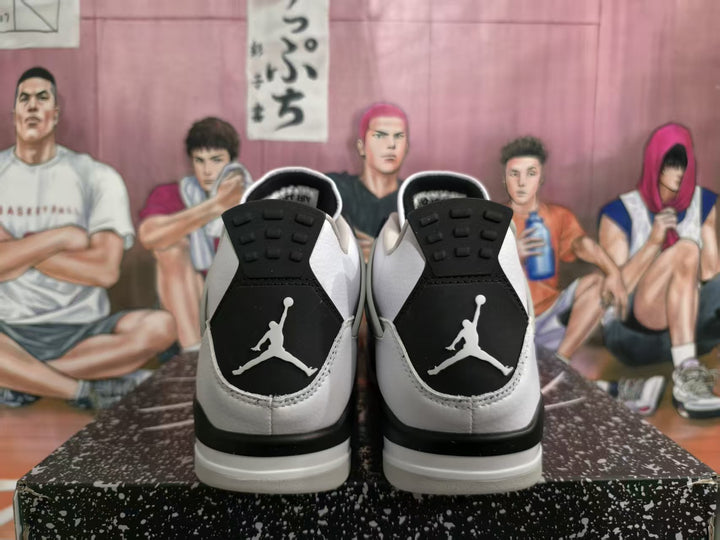 Rear view of white and black high-top sneakers showing contrasting heel panels, textured soles, and Jumpman-style heel logos.
