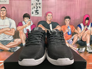 Front view of black lace-up basketball sneakers with white midsoles and tongue branding.