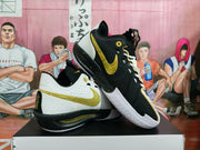 Angled view of the sneakers showing contrasting black and white panels, gold accents, and textured outsoles.
